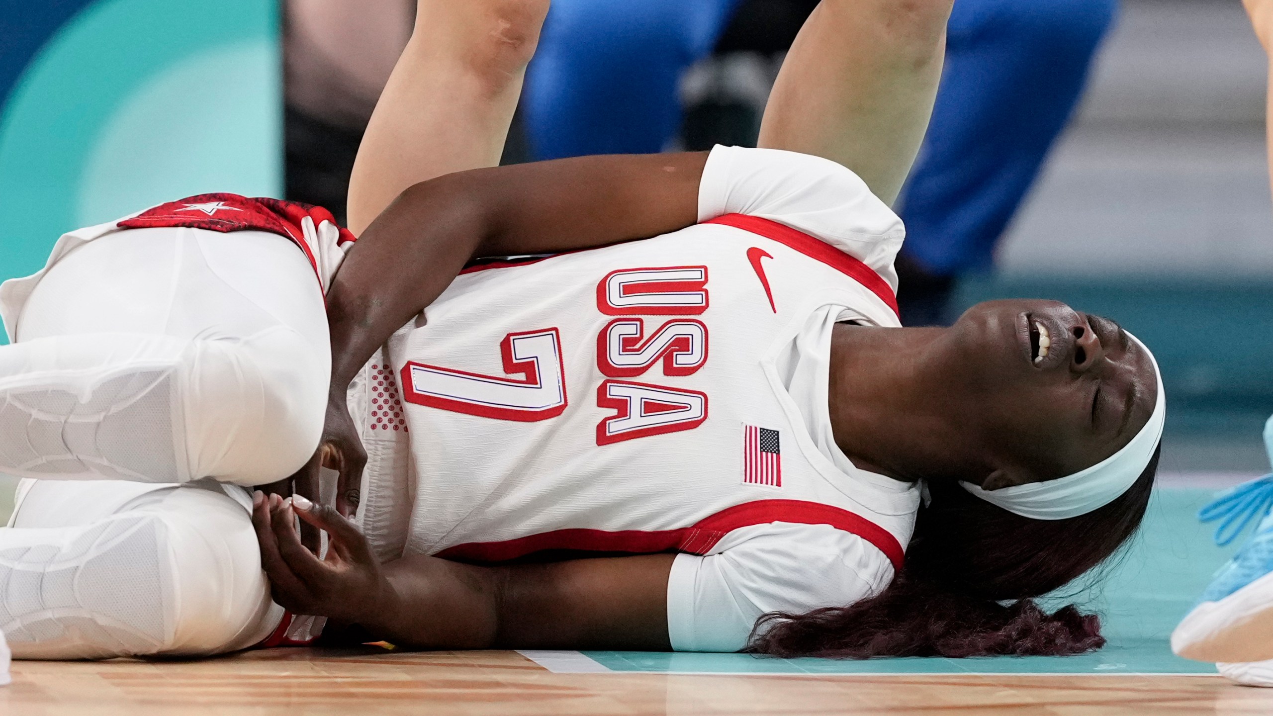 Kahleah Copper, of the Unites States, on the floor after being injured in a women's basketball game against Japan at the 2024 Summer Olympics, Monday, July 29, 2024, in Villeneuve-d'Ascq, France. (AP Photo/Mark J. Terrill)