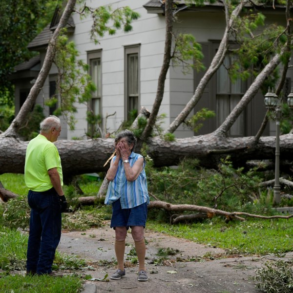 Jackie Jecmenek, right, talks with city worker Bobby Head as she stands in front of her neighbor's home after Beryl passed, Monday, July 8, 2024, in Bay City, Texas.