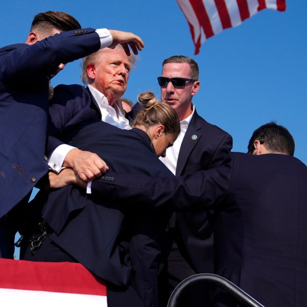 Republican presidential candidate former President Donald Trump is surrounded by U.S. Secret Service agents at a campaign rally.