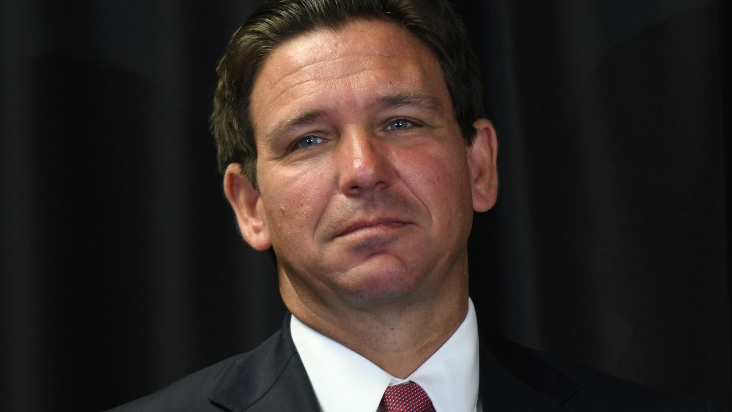 Florida Gov. Ron DeSantis listens to a speaker at a press conference in Sanford, Florida