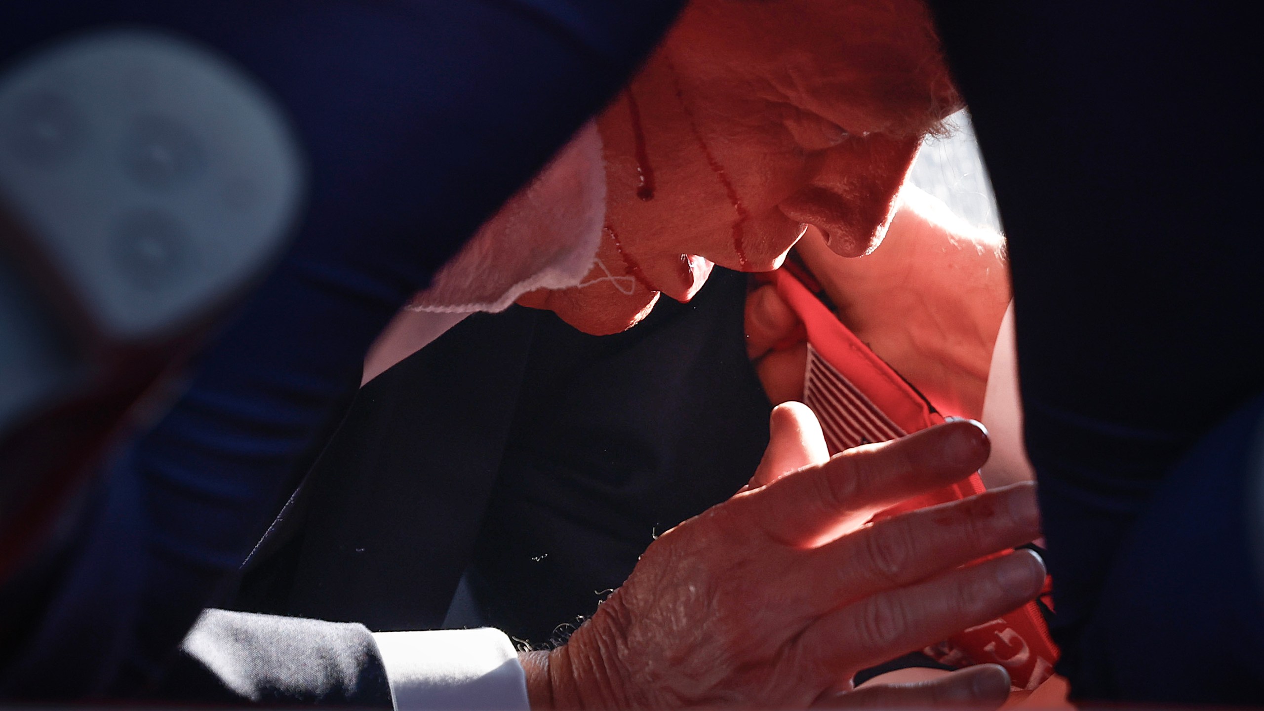 An injured Donald Trump on the ground shielded by Secret Service.