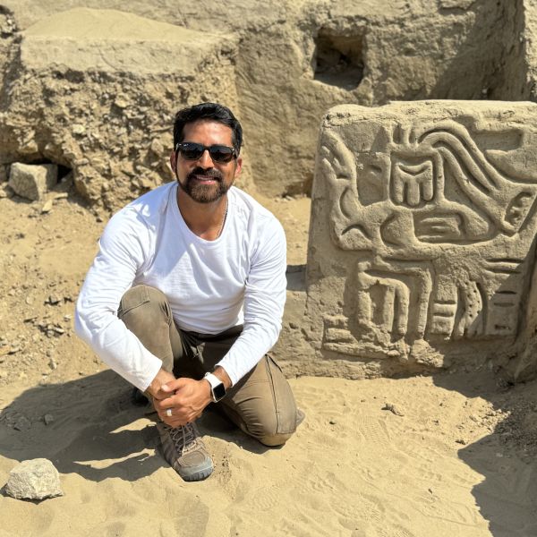 An archaeologist stands outside of ancient ruins in Peru.