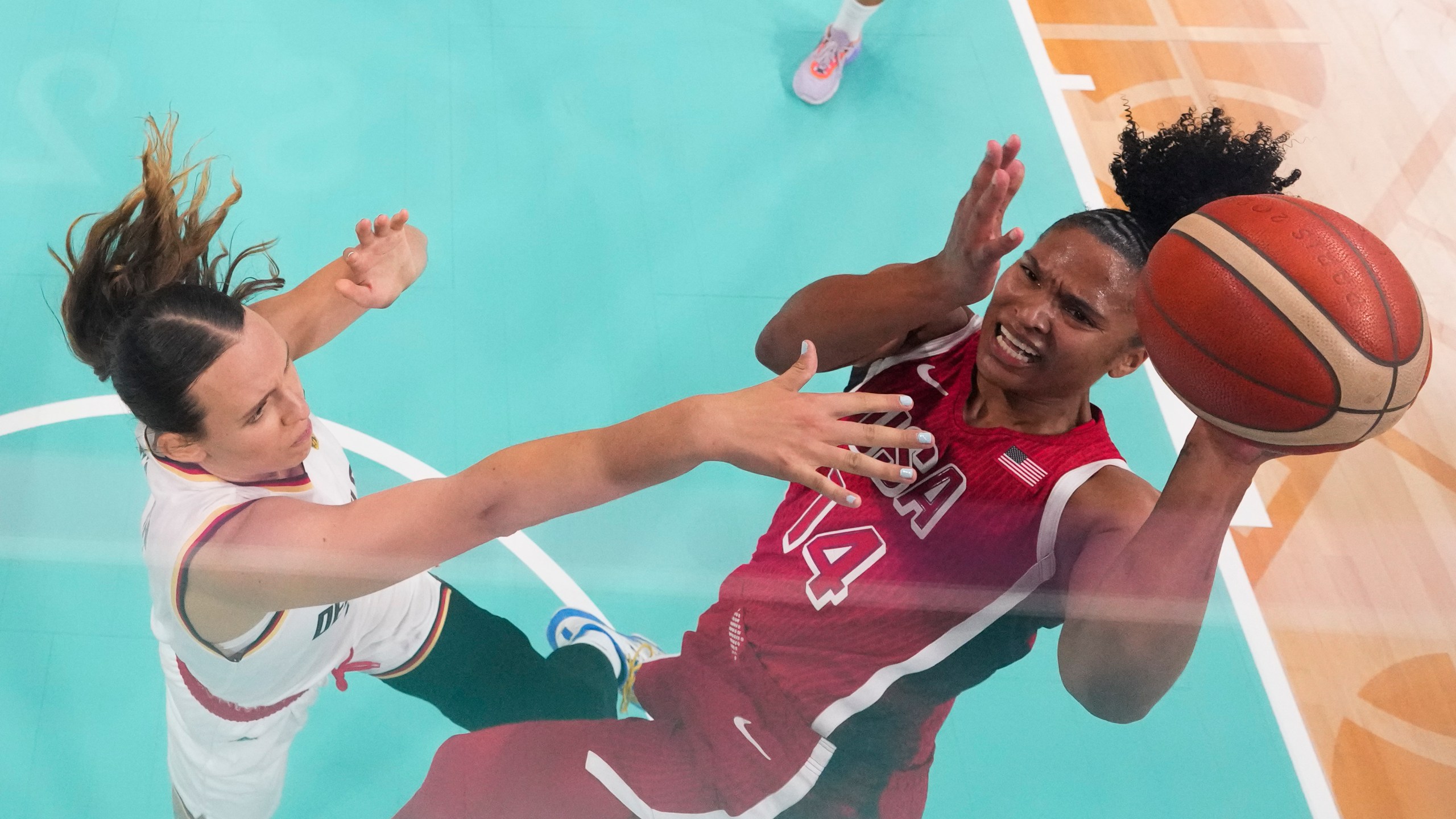 Alyssa Thomas (14), of the United States, shoots over Emily Bessoir (22), of Germany, in a women's basketball game at the 2024 Summer Olympics, Sunday, Aug. 4, 2024, in Villeneuve-d'Ascq, France. (AP Photo/Mark J. Terrill, Pool)