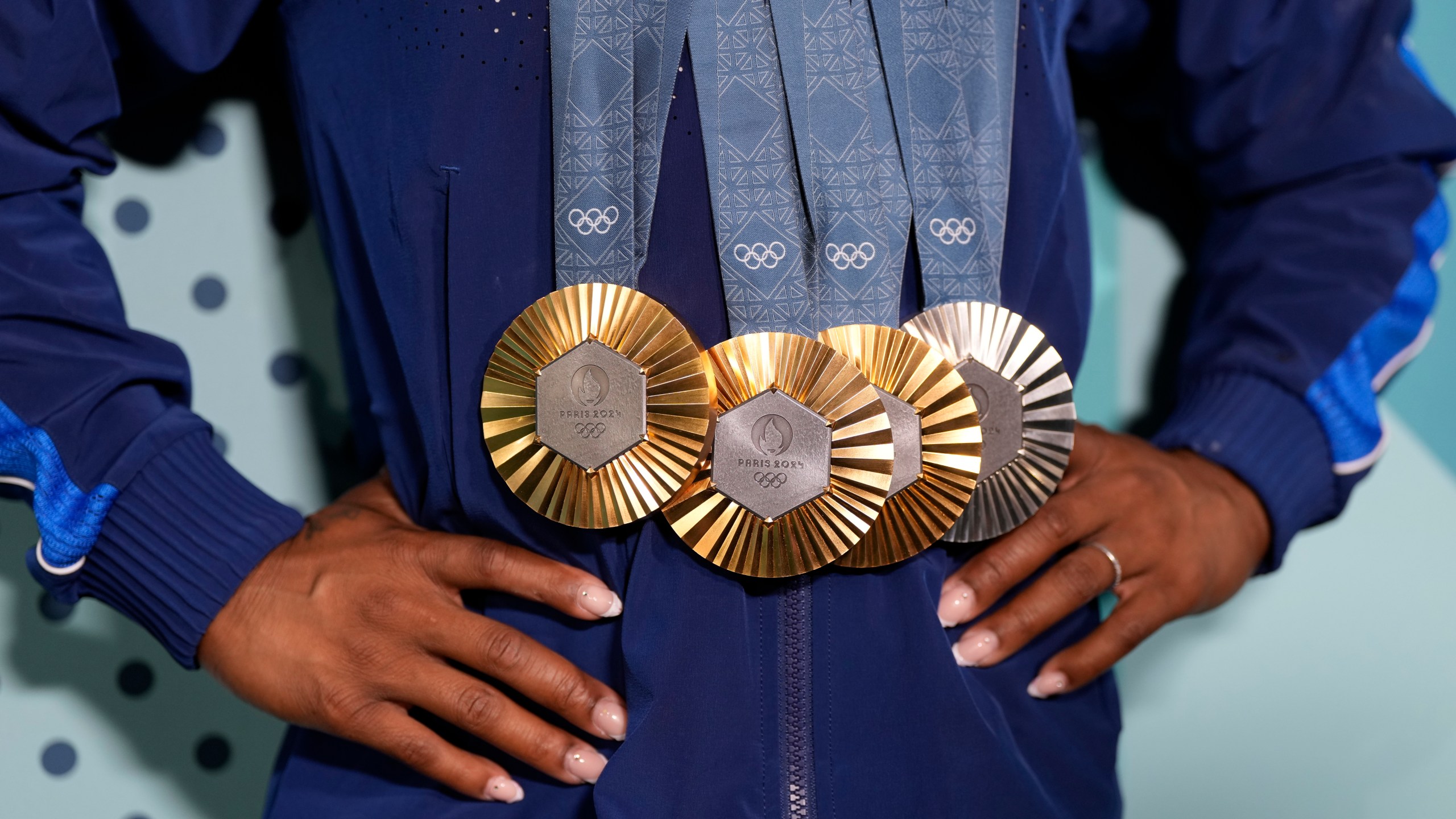 Simone Biles, of the United States, holds up her medals after the women's artistic gymnastics individual apparatus finals Bercy Arena at the 2024 Summer Olympics, Monday, Aug. 5, 2024, in Paris, France. (AP Photo/Charlie Riedel)