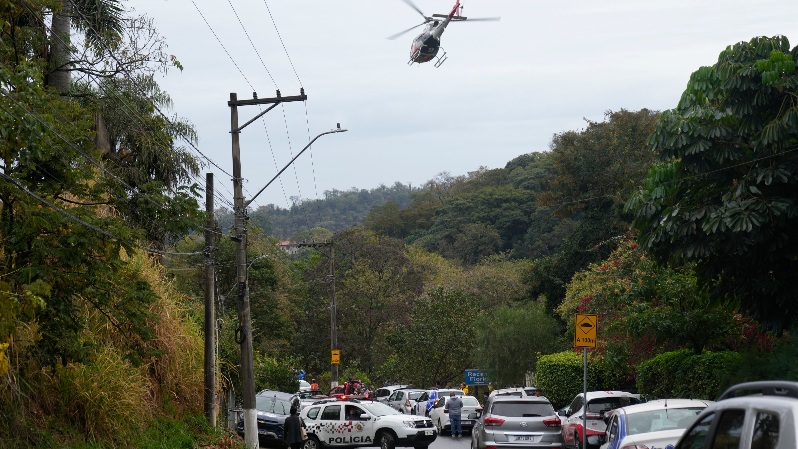 Police patrol the street leading to the gated community where a plane crashed in Vinhedo, Sao Paulo state, Brazil, Friday, Aug. 9, 2024. (AP Photo/Andre Penner)