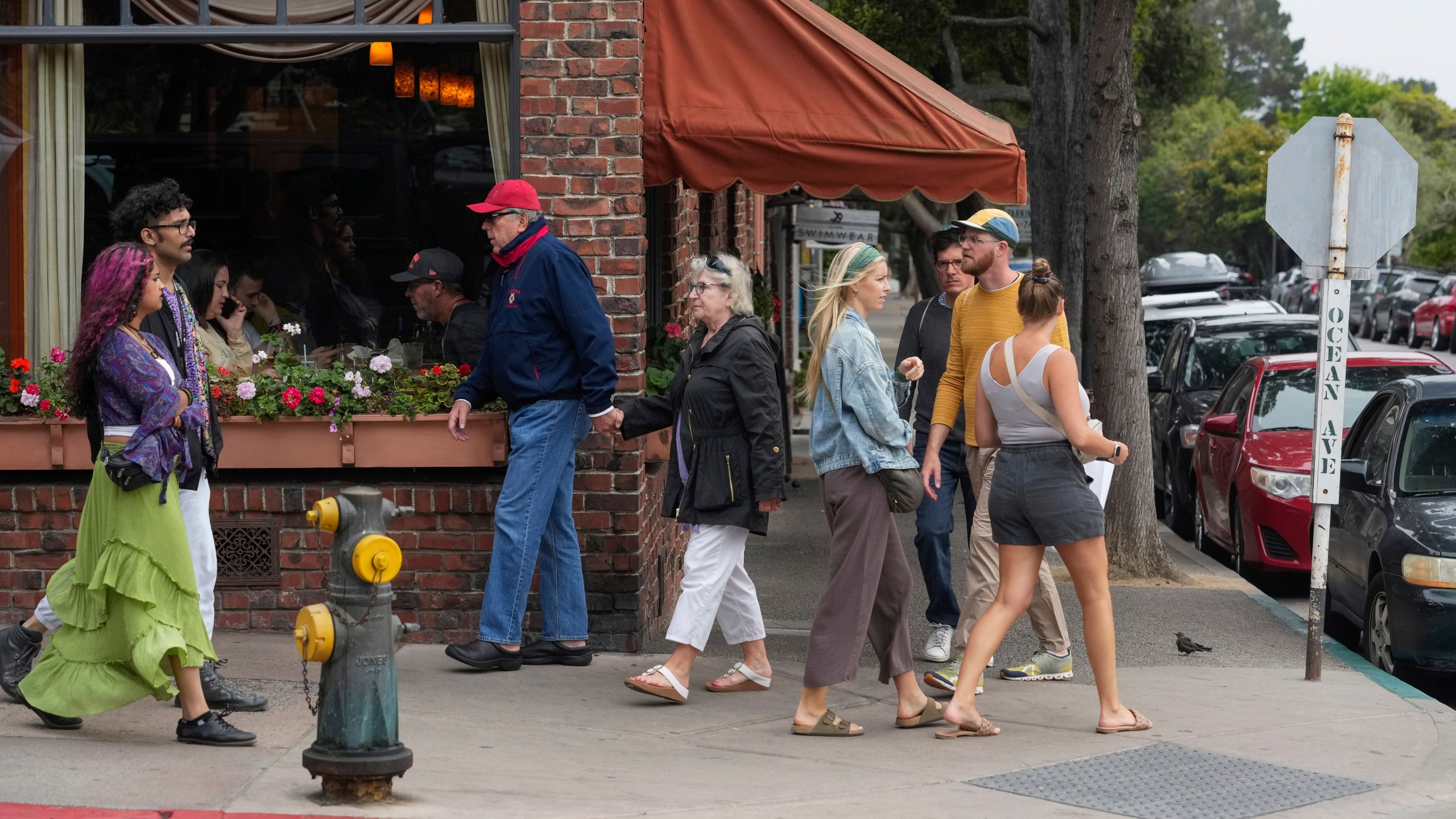 People walk along Ocean Avenue, Tuesday, July 23, 2024, in Carmel-By-The-Sea, Calif. (AP Photo/Godofredo A. Vásquez)