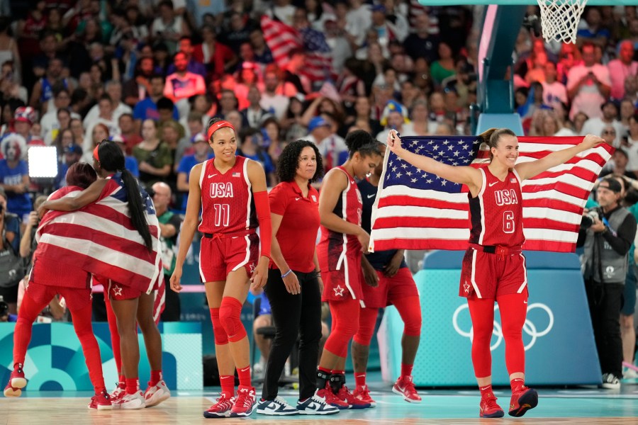 The United States team celebrates after a women's gold medal basketball game at Bercy Arena at the 2024 Summer Olympics, Sunday, Aug. 11, 2024, in Paris, France. (AP Photo/Mark J. Terrill)