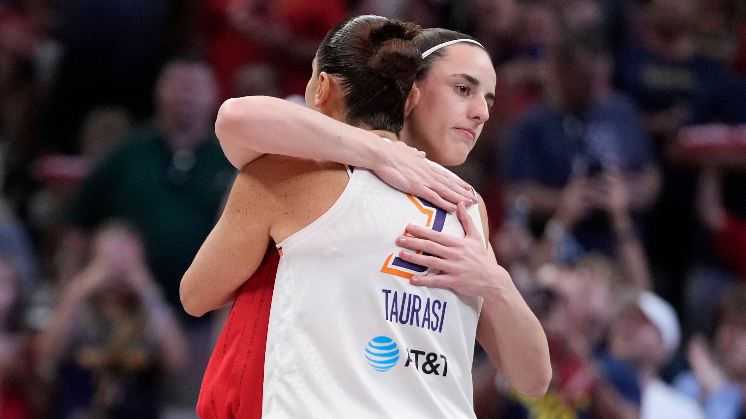 Indiana Fever guard Caitlin Clark hugs Phoenix Mercury's Diana Taurasi (3) before the first half of a WNBA basketball game, Friday, Aug. 16, 2024, in Indianapolis. (AP Photo/Darron Cummings)