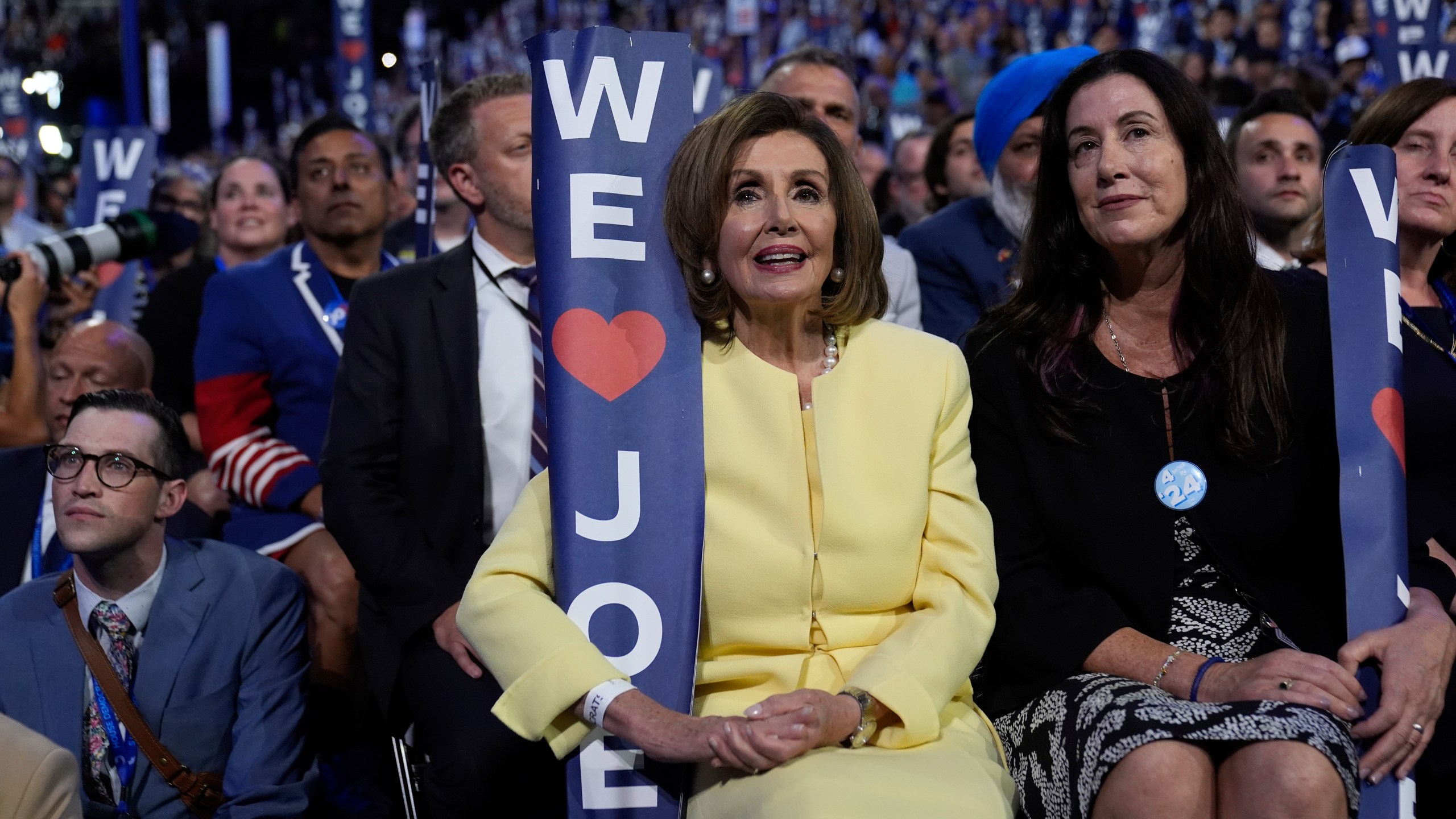 Rep. Nancy Pelosi, D-Calif., holds a sign as President Joe Biden speaks during the Democratic National Convention Monday, Aug. 19, 2024, in Chicago. (AP Photo/Paul Sancya)