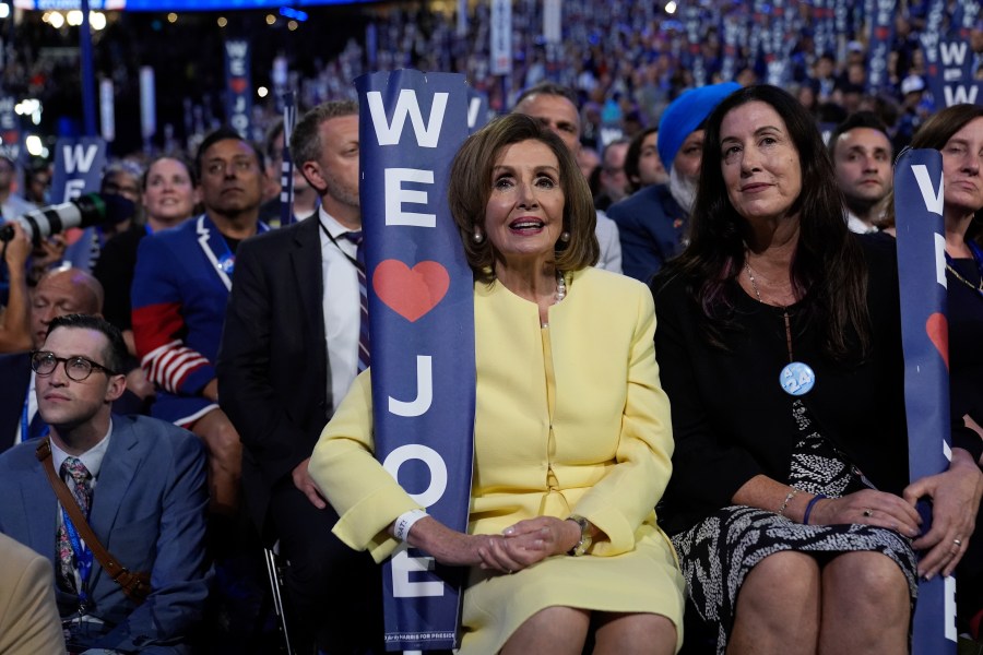 Rep. Nancy Pelosi, D-Calif., holds a sign as President Joe Biden speaks during the Democratic National Convention Monday, Aug. 19, 2024, in Chicago. (AP Photo/Paul Sancya)