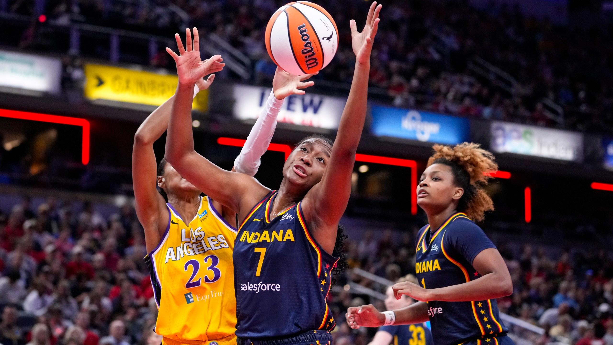 Indiana Fever forward Aliyah Boston (7) grabs a rebound in front of Los Angeles Sparks forward Azura Stevens (23) in the first half of a WNBA basketball game in Indianapolis, Wednesday, Sept. 4, 2024. (AP Photo/Michael Conroy)