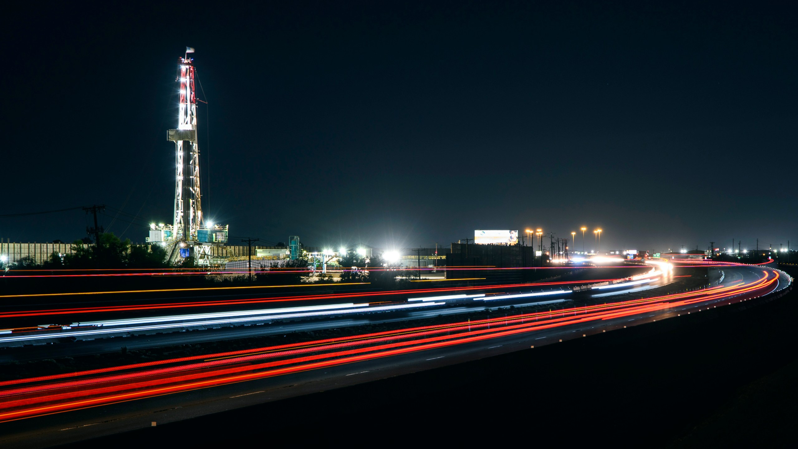 FILE - Motorists drive past an oil rig set up alongside Interstate 20, July 7, 2022, in Midland, Texas. (Eli Hartman/Odessa American via AP, File)