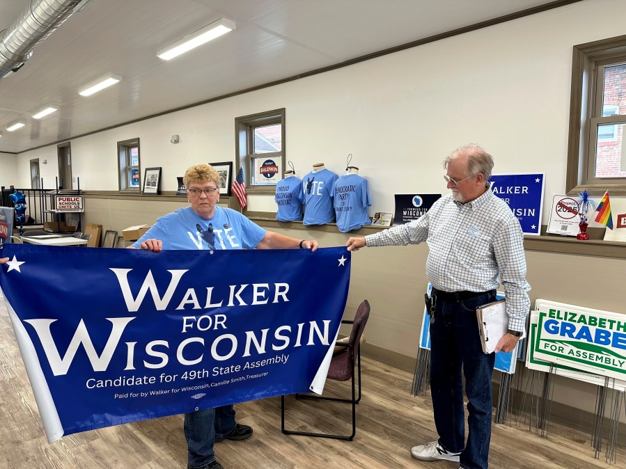 Grant County Democratic Party Chair Joyce Bos, left, and Democratic legislative candidate Scott Abbot Walker inspect a campaign banner Friday, Sept. 6, 2024, in the county party headquarters in Platteville, Wis. (AP Photo/Todd Richmond)