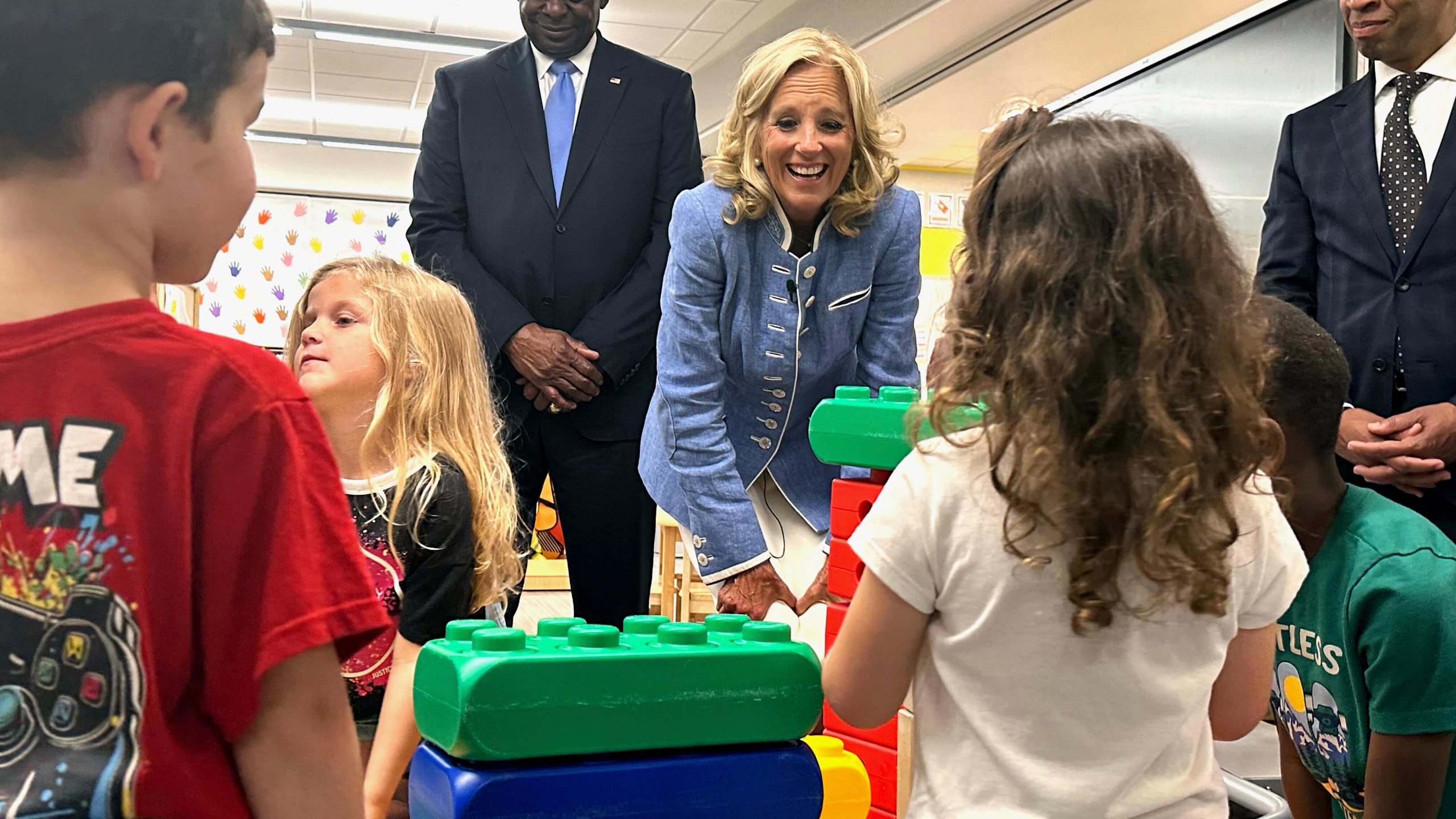 First lady Jill Biden, center, and Defense Secretary Lloyd Austin, left, watch four and five-year-olds build with blocks at a military early childhood education program at Maxwell Air Force Base in Alabama, Friday, Sept. 13, 2024. (AP Photo/Tara Copp)