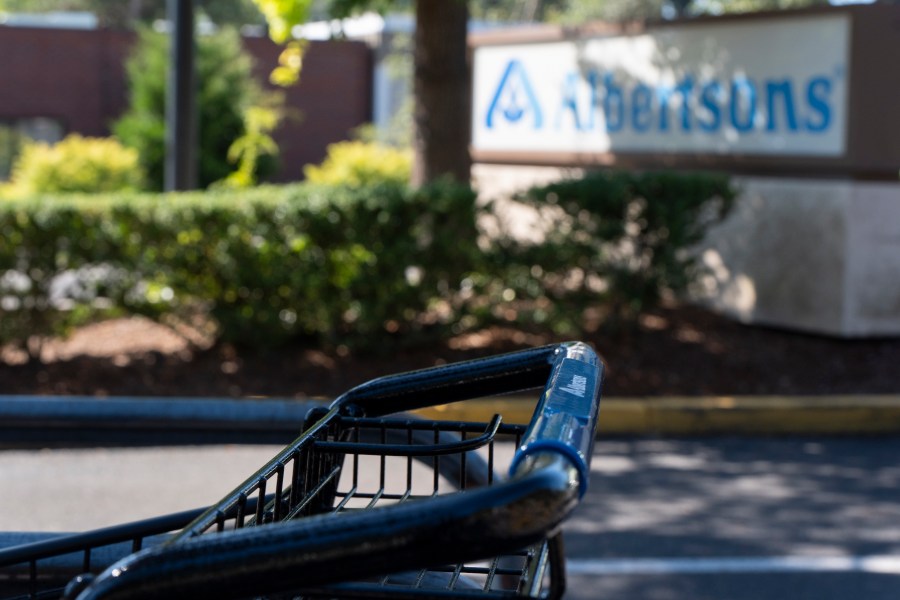 FILE - A grocery cart rests in a cart return area with a sign for Albertsons grocery store in the background on Aug. 26, 2024, in Lake Oswego, Ore. (AP Photo/Jenny Kane, File)