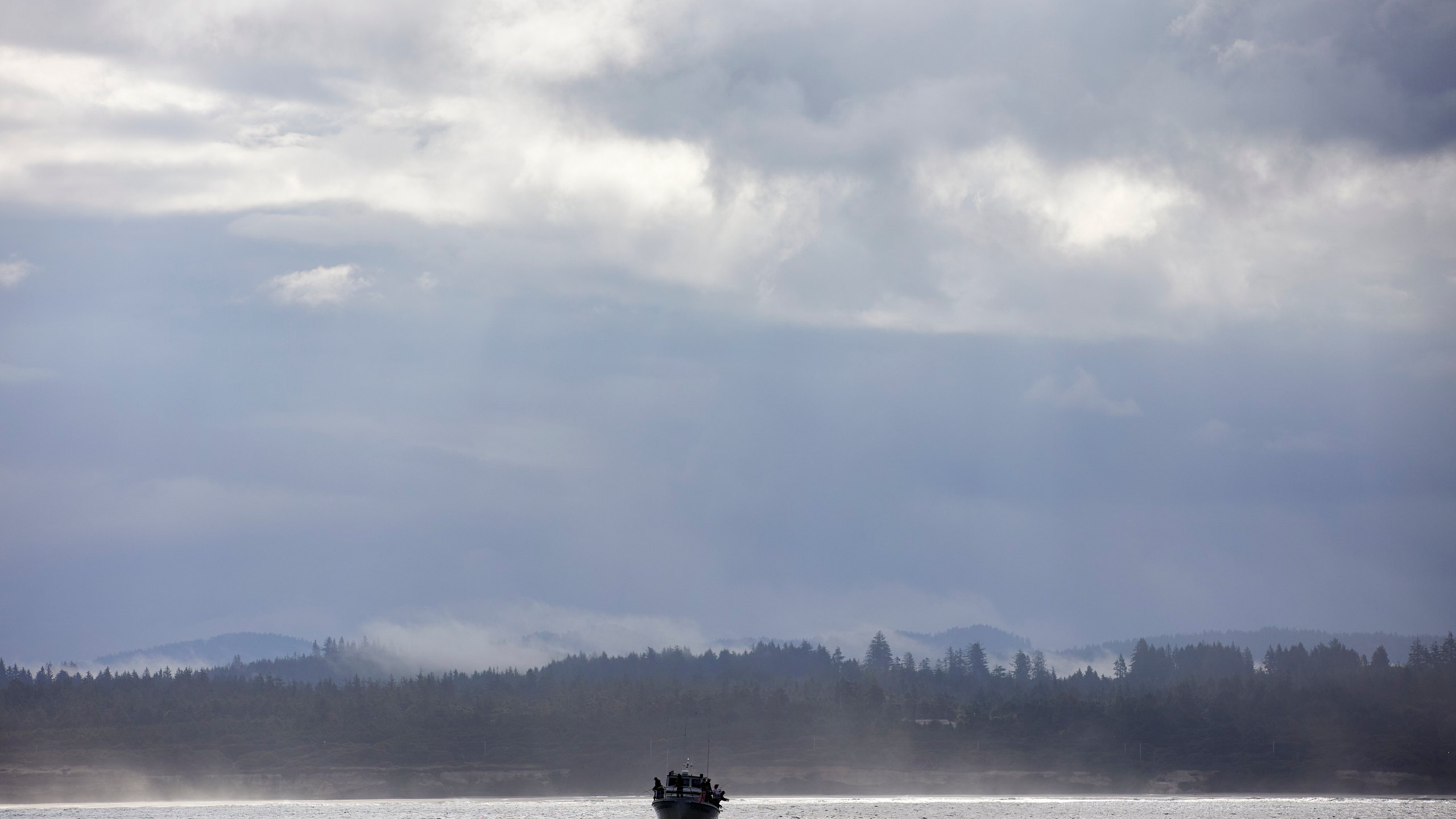 Fishermen fish in the Pacific Ocean near the wave energy test site in Newport, Ore., Friday, Aug. 23, 2024, where private developers will be able to test devices that they've designed to harness energy from waves. (AP Photo/Craig Mitchelldyer)