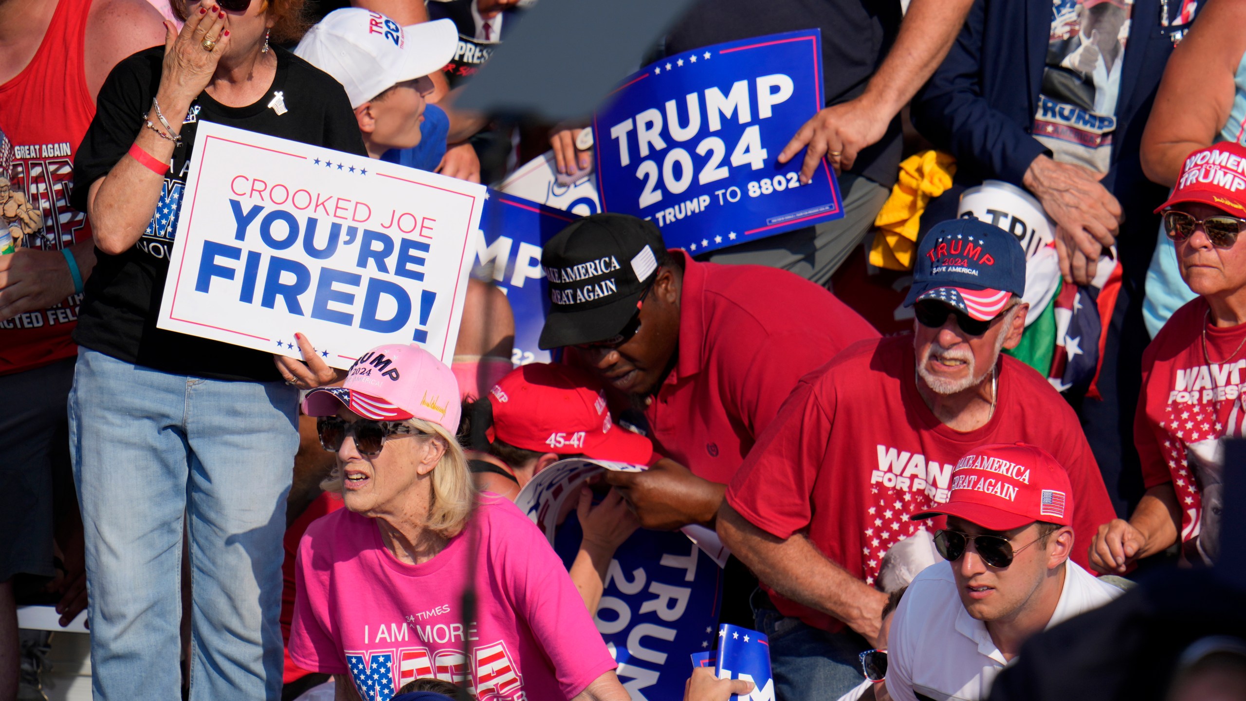 FILE - Members of the crowd react as U.S. Secret Service agents surround Republican presidential candidate former President Donald Trump at a campaign event in Butler, Pa., July 13, 2024. (AP Photo/Gene J. Puskar, File)