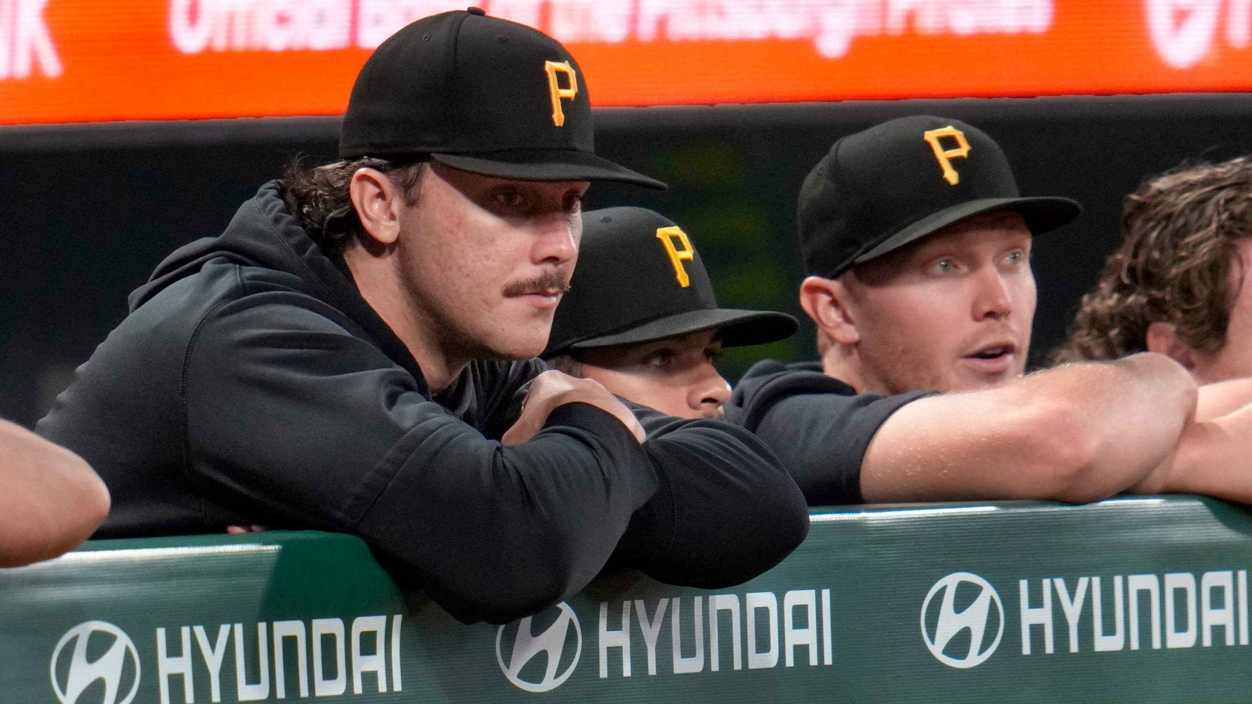 Pittsburgh Pirates pitcher Paul Skenes, left, with fellow pitchers Jared Jones, center, and Mitch Keller, right, watch from the dugout railing during the seventh inning of a baseball game against the Milwaukee Brewers in Pittsburgh, Tuesday, Sept. 24, 2024. (AP Photo/Gene J. Puskar)