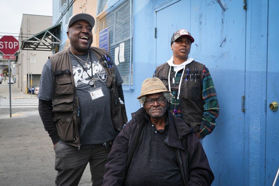 Homeless resident Larry James Bell, seated, is seen with Ventrell Johnson, left, and Jonice Pauley of the San Francisco Homeless Outreach Team, Tuesday, Sept. 10, 2024, in San Francisco. (AP Photo/Terry Chea)