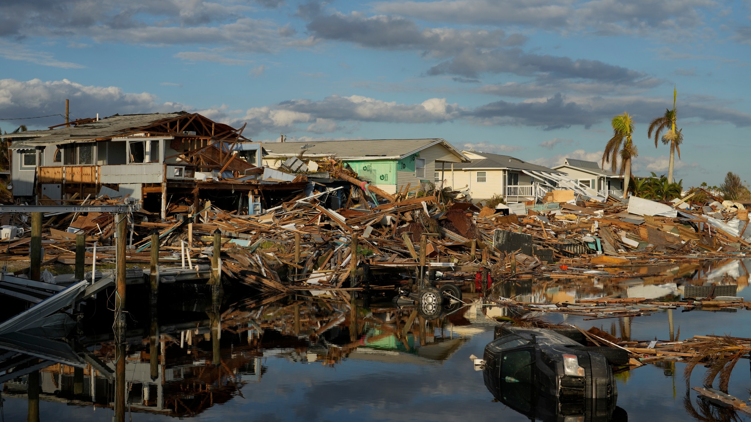 FILE - Cars and debris from washed away homes line a canal in Fort Myers Beach, Fla., Oct. 5, 2022, one week after the passage of Hurricane Ian. (AP Photo/Rebecca Blackwell, File)