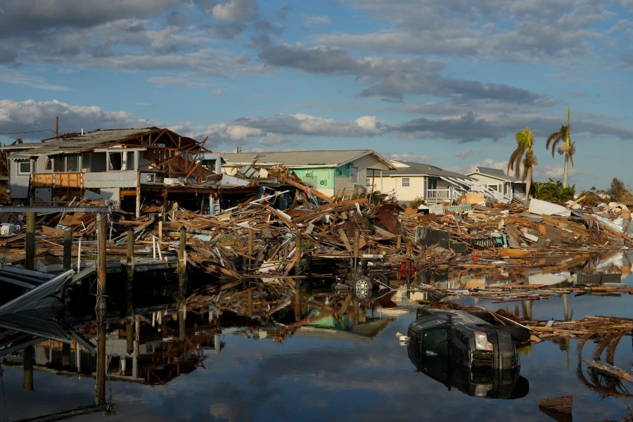 FILE - Cars and debris from washed away homes line a canal in Fort Myers Beach, Fla., Oct. 5, 2022, one week after the passage of Hurricane Ian. (AP Photo/Rebecca Blackwell, File)