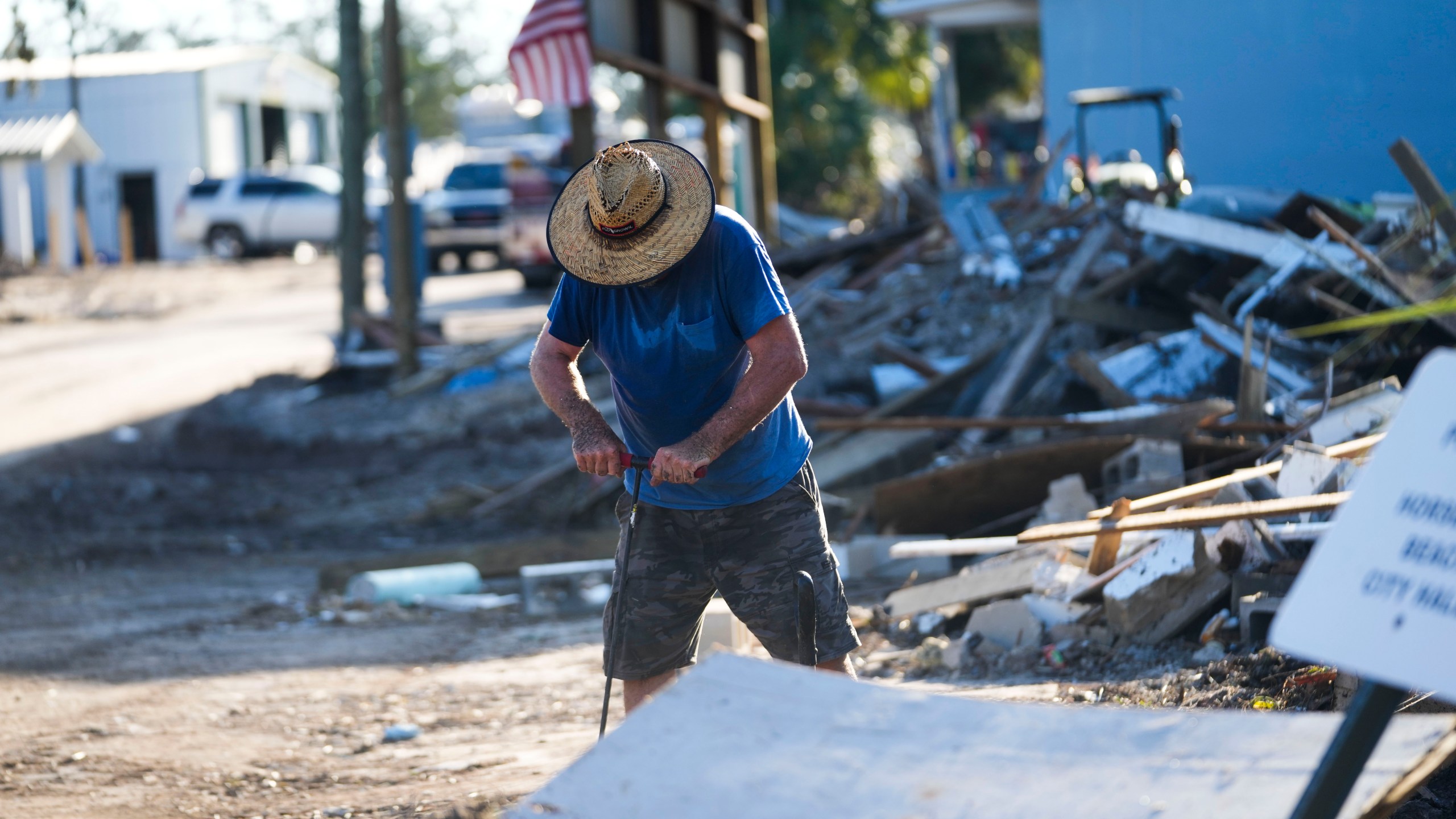 Chris Jordan, maintenance manager for Horseshoe Beach, tries to find a water shutoff valve amid the rubble of the destroyed city hall in the aftermath of Hurricane Helene, in Horseshoe Beach, Fla., Sunday, Sept. 29, 2024. (AP Photo/Gerald Herbert)