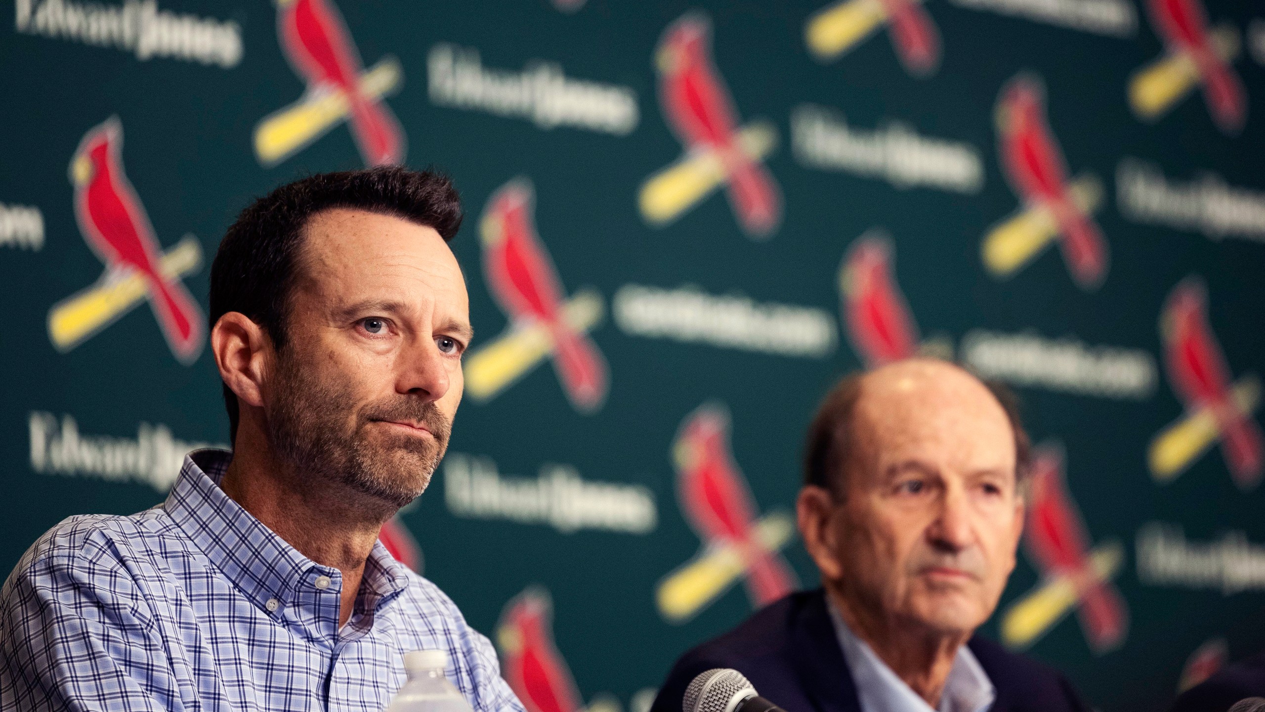 St. Louis Cardinals Chairman and Chief Executive Officer Bill DeWitt Jr., left, reads a statement at the beginning of a press conference as his father, Bill DeWitt, looks on Monday, Sept. 30, 2024, at Busch Stadium in St. Louis. (Zachary Linhares/St. Louis Post-Dispatch via AP)