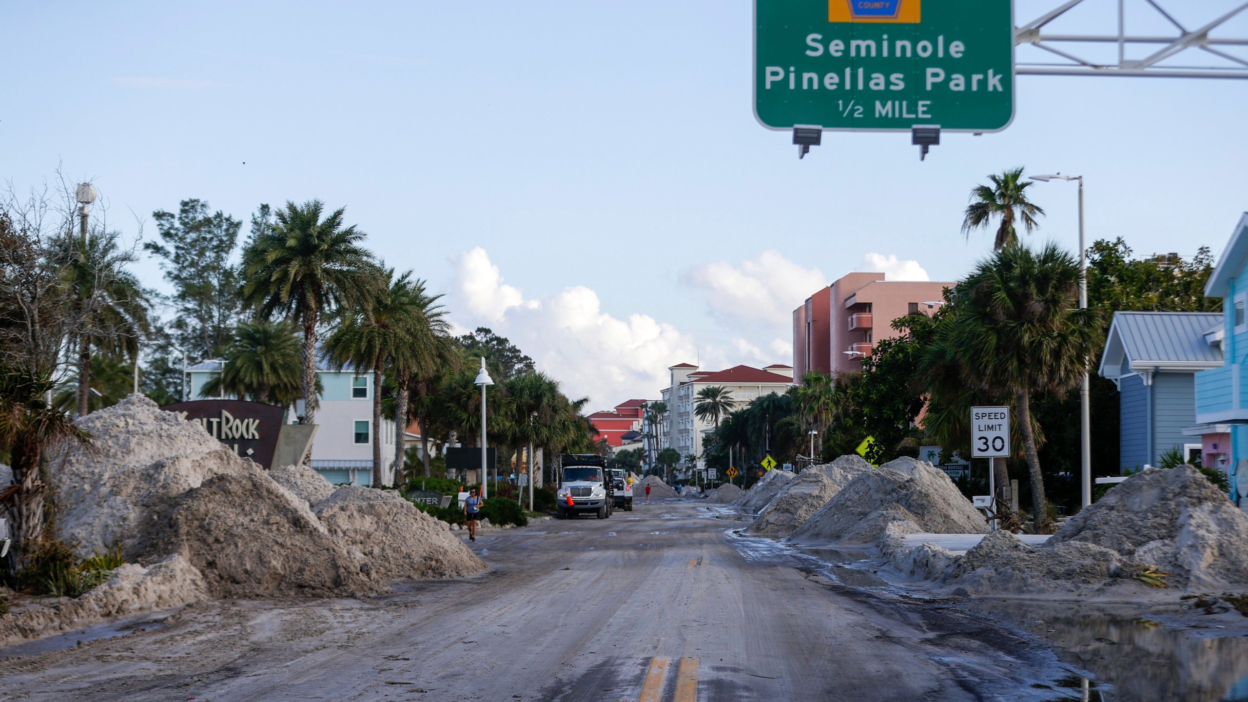 Crews work to clean up the tons of sand and debris pushed onto Gulf Boulevard from Hurricane Helene storm surge, Saturday, Sept. 28, 2024, in Madeira Beach, Fla. (Luis Santana/Tampa Bay Times via AP)