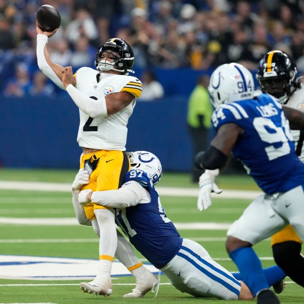 Pittsburgh Steelers quarterback Justin Fields (2) gets off a pass as he is hit by Indianapolis Colts defensive end Laiatu Latu (97) during the second half of an NFL football game Sunday, Sept. 29, 2024, in Indianapolis. (AP Photo/Darron Cummings)