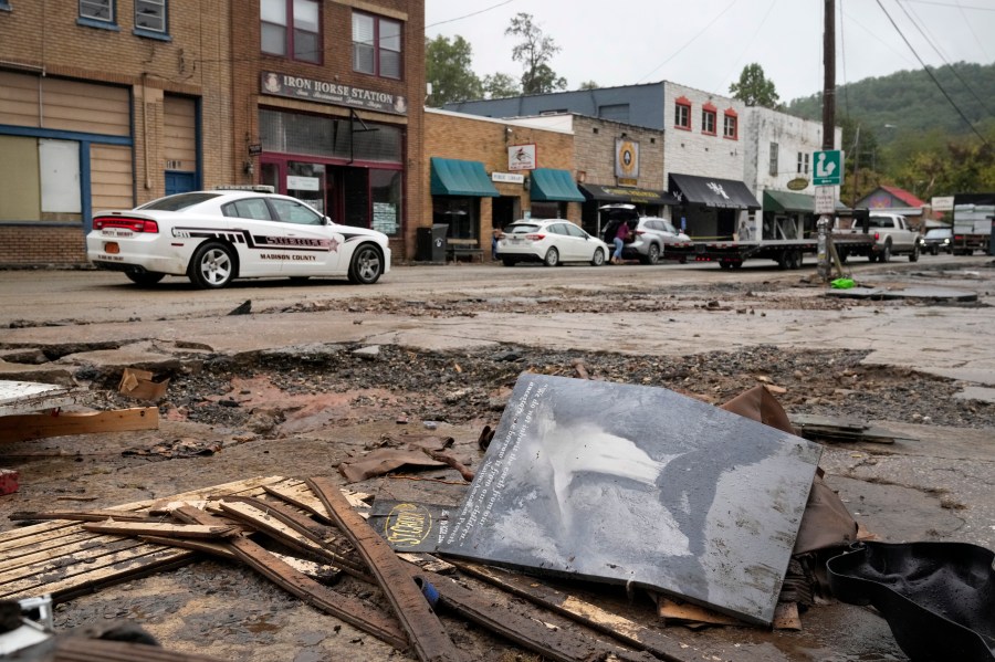 A Madison County sheriff's vehicle passes damaged buildings along Bridge Street in the aftermath of Hurricane Helene Tuesday, Oct. 1, 2024, in Hot Springs, N.C. (AP Photo/Jeff Roberson)