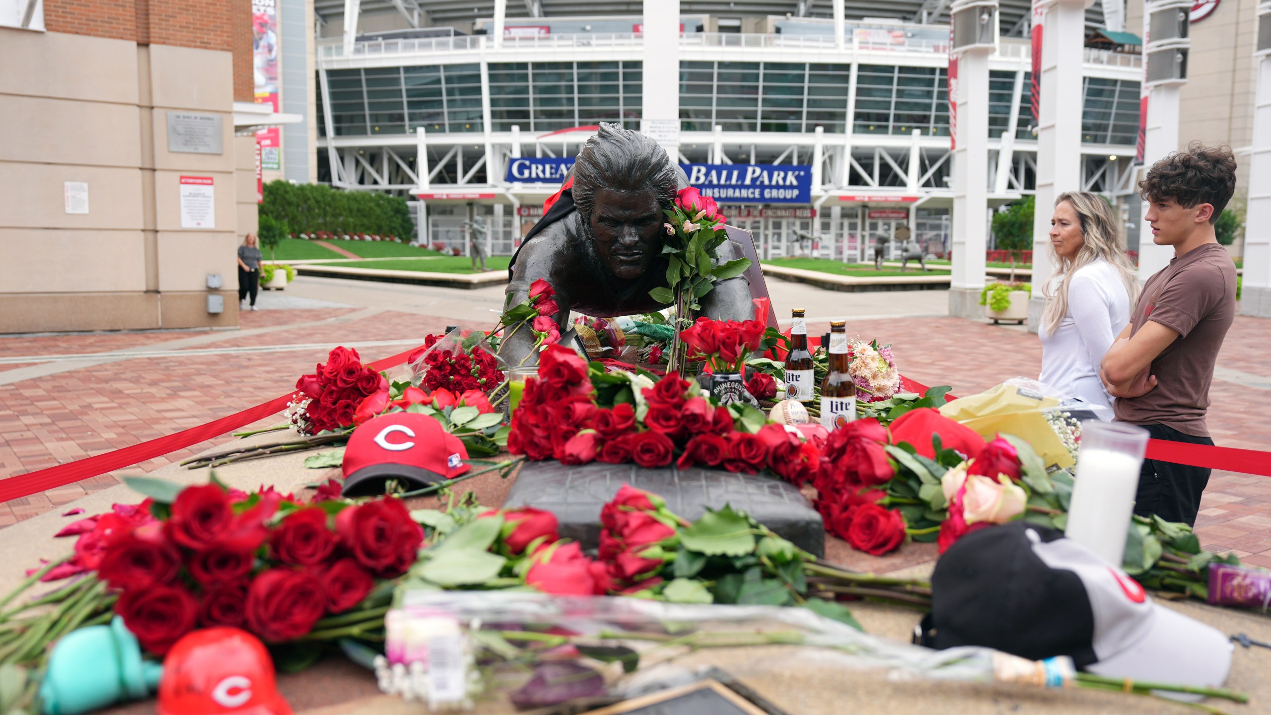 Jodi and Landon Funky, 17, right, both of Independence Ky., visit the statue of Cincinnati Reds legend Pete Rose, Tuesday, Oct. 1, 2024, in front of Great American Ball Park in Cincinnati. (AP Photo/Kareem Elgazzar)