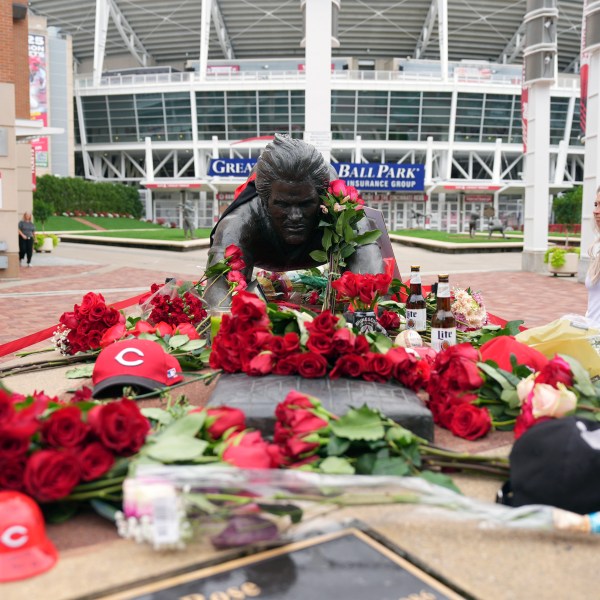 Jodi and Landon Funky, 17, right, both of Independence Ky., visit the statue of Cincinnati Reds legend Pete Rose, Tuesday, Oct. 1, 2024, in front of Great American Ball Park in Cincinnati. (AP Photo/Kareem Elgazzar)