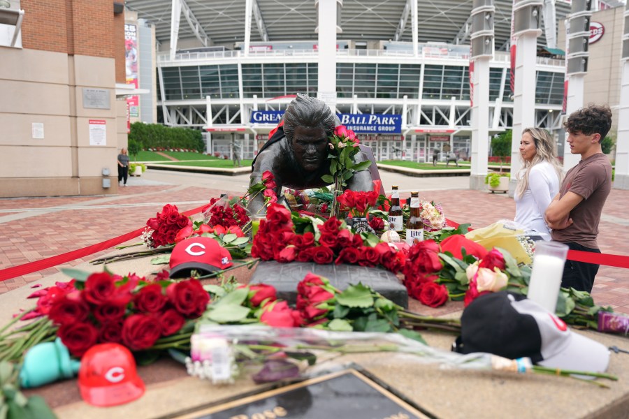 Jodi and Landon Funky, 17, right, both of Independence Ky., visit the statue of Cincinnati Reds legend Pete Rose, Tuesday, Oct. 1, 2024, in front of Great American Ball Park in Cincinnati. (AP Photo/Kareem Elgazzar)