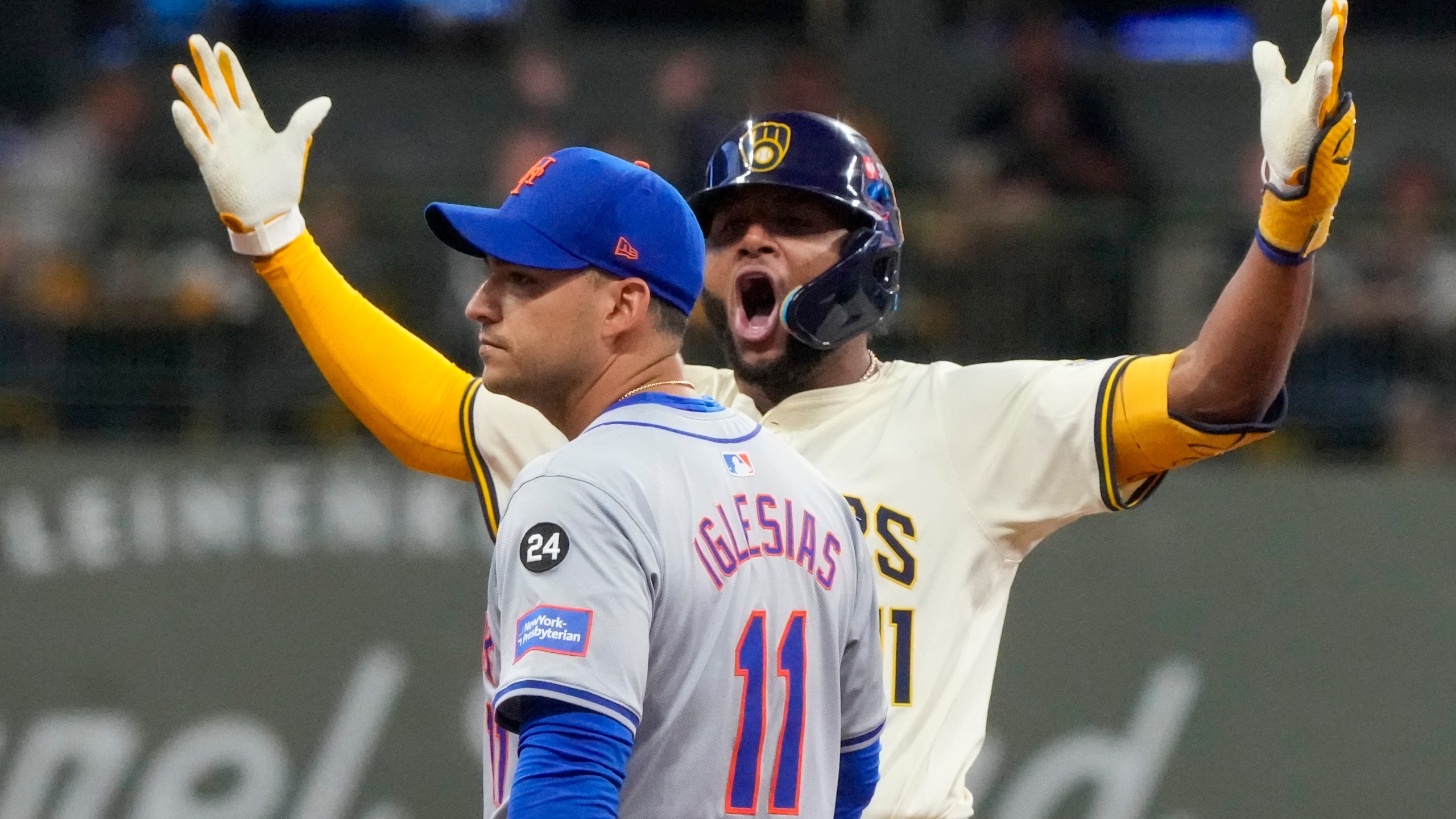 Milwaukee Brewers' Jackson Chourio reacts in front of New York Mets' Jose Iglesias after hitting an RBI double during the fourth inning of Game 2 of a National League wild card baseball game Tuesday, Oct. 1, 2024, in Milwaukee. (AP Photo/Morry Gash)