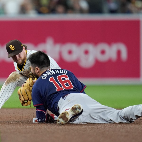 Atlanta Braves' Travis d'Arnaud (16) slides into second base with a double before the tag attempt from San Diego Padres second baseman Jake Cronenworth during the fourth inning in Game 1 of an NL Wild Card Series baseball game Tuesday, Oct. 1, 2024, in San Diego. (AP Photo/Gregory Bull)