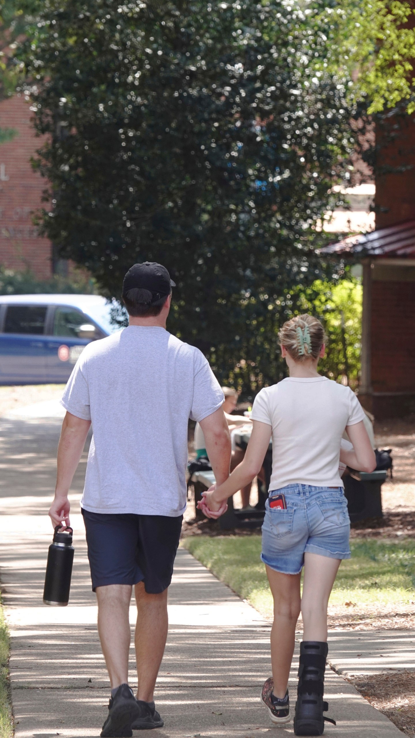 A couple holds hands at the University of Mississippi campus in Oxford, Miss., Wednesday, Aug. 28, 2024. (AP Photo/Karen Pulfer Focht)