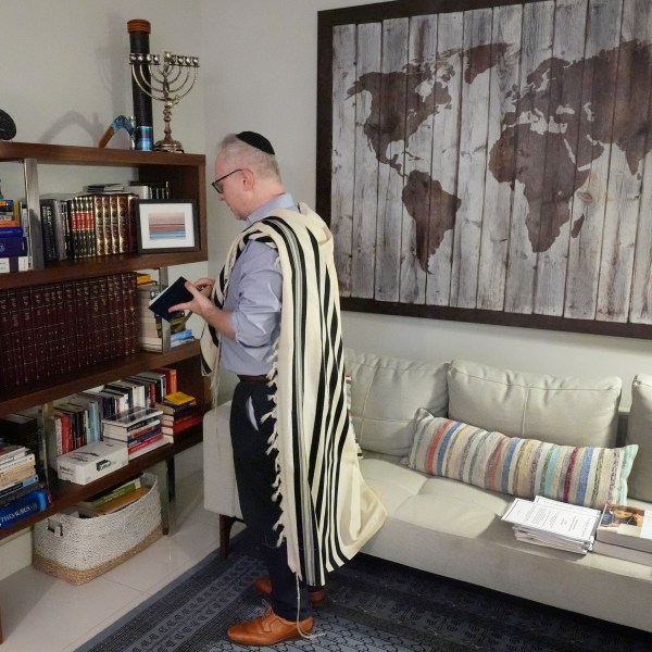 Daniel Gammerman gathers prayer items that he will use to privately worship at home during the Jewish High Holy Days, Thursday, Sept. 26, 2024, in Miami. (AP Photo/Wilfredo Lee)