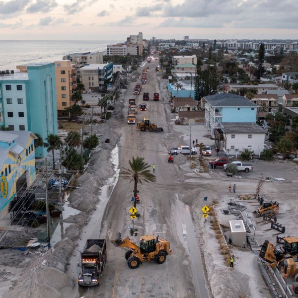 Crews work to clean up the tons of sand and debris pushed onto Gulf Boulevard from Hurricane Helene storm surge, Saturday, Sept. 28, 2024, in Madeira Beach, Fla. (Luis Santana/Tampa Bay Times via AP)