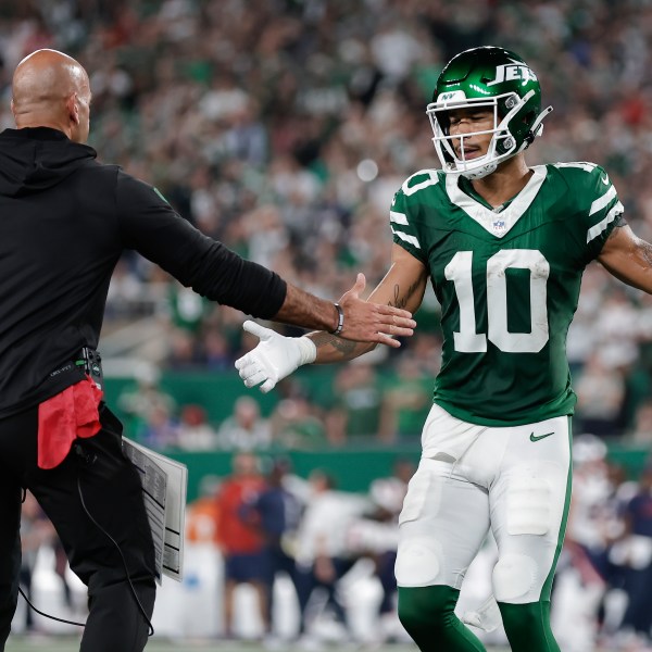 New York Jets wide receiver Allen Lazard (10) is congratulated by New York Jets head coach Robert Saleh after Lazard scored a touchdown against the New England Patriots during the first quarter of an NFL football game, Thursday, Sept. 19, 2024, in East Rutherford, N.J. (AP Photo/Adam Hunger)