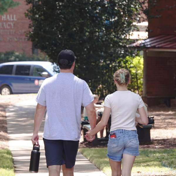 A couple holds hands at the University of Mississippi campus in Oxford, Miss., Wednesday, Aug. 28, 2024. (AP Photo/Karen Pulfer Focht)