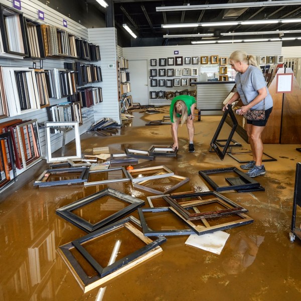 FILE - Employees Linda Bandy, left, and Carissa Sheehan clean up International Moulding frame shop damaged by floodwater from Hurricane Helene on North Green Street, Sept. 30, 2024, in Morganton, N.C. (AP Photo/Kathy Kmonicek, File)