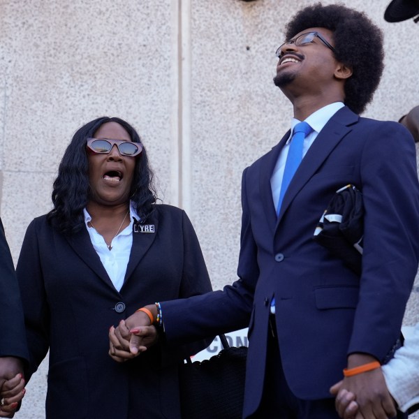 RowVaughn Wells, left, mother of Tyre Nichols, shouts her son's name with Rep. Justin J. Pearson, D-Memphis, second from right, before entering the federal courthouse for the trial of three former Memphis police officers charged in the 2023 fatal beating of her son Wednesday, Oct. 2, 2024, in Memphis, Tenn. (AP Photo/George Walker IV)