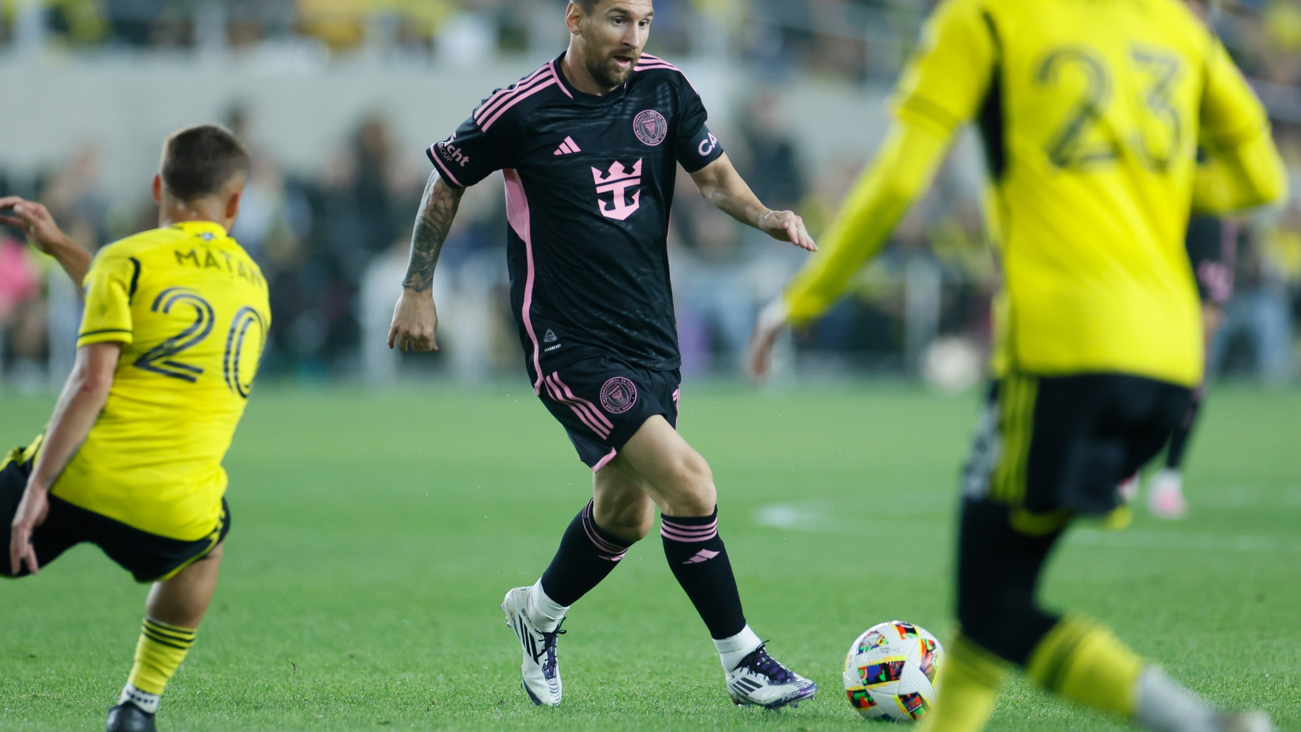 Inter Miami's Lionel Messi, center, tries to dribble between Columbus Crew's Alexandru Matan, left, and Mohamed Farsi during the first half of an MLS soccer match, Wednesday, Oct. 2, 2024, in Columbus, Ohio. (AP Photo/Jay LaPrete)