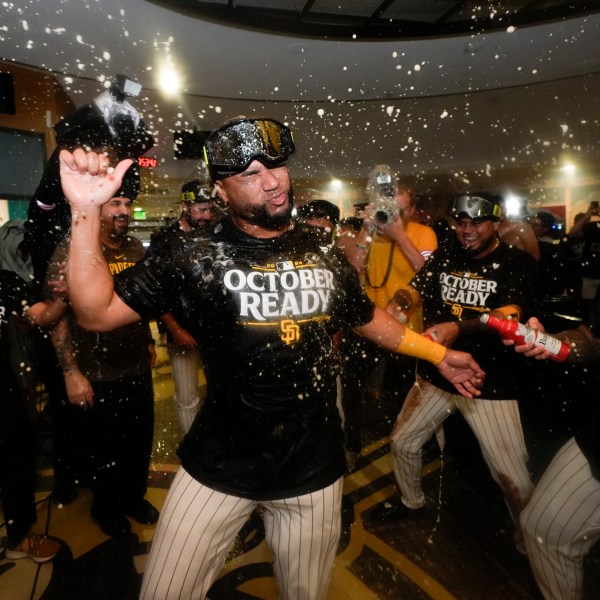 San Diego Padres players celebrate in the dugout after defeating the Atlanta Braves in Game 2 of an NL Wild Card Series baseball game Wednesday, Oct. 2, 2024, in San Diego. (AP Photo/Gregory Bull)