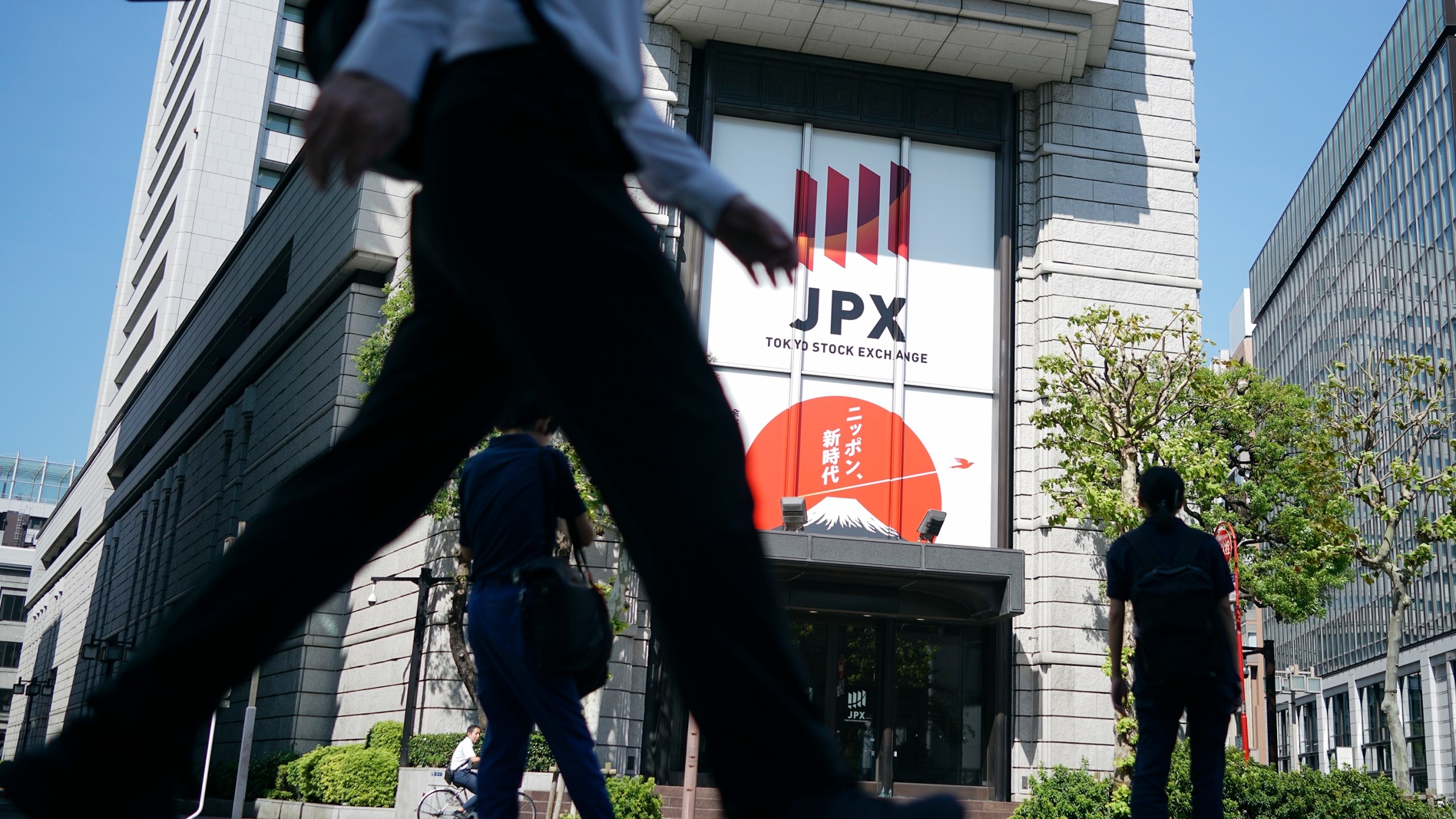 A person walks in front of the Tokyo Stock Exchange building Wednesday, Oct. 2, 2024, in Tokyo. (AP Photo/Eugene Hoshiko)