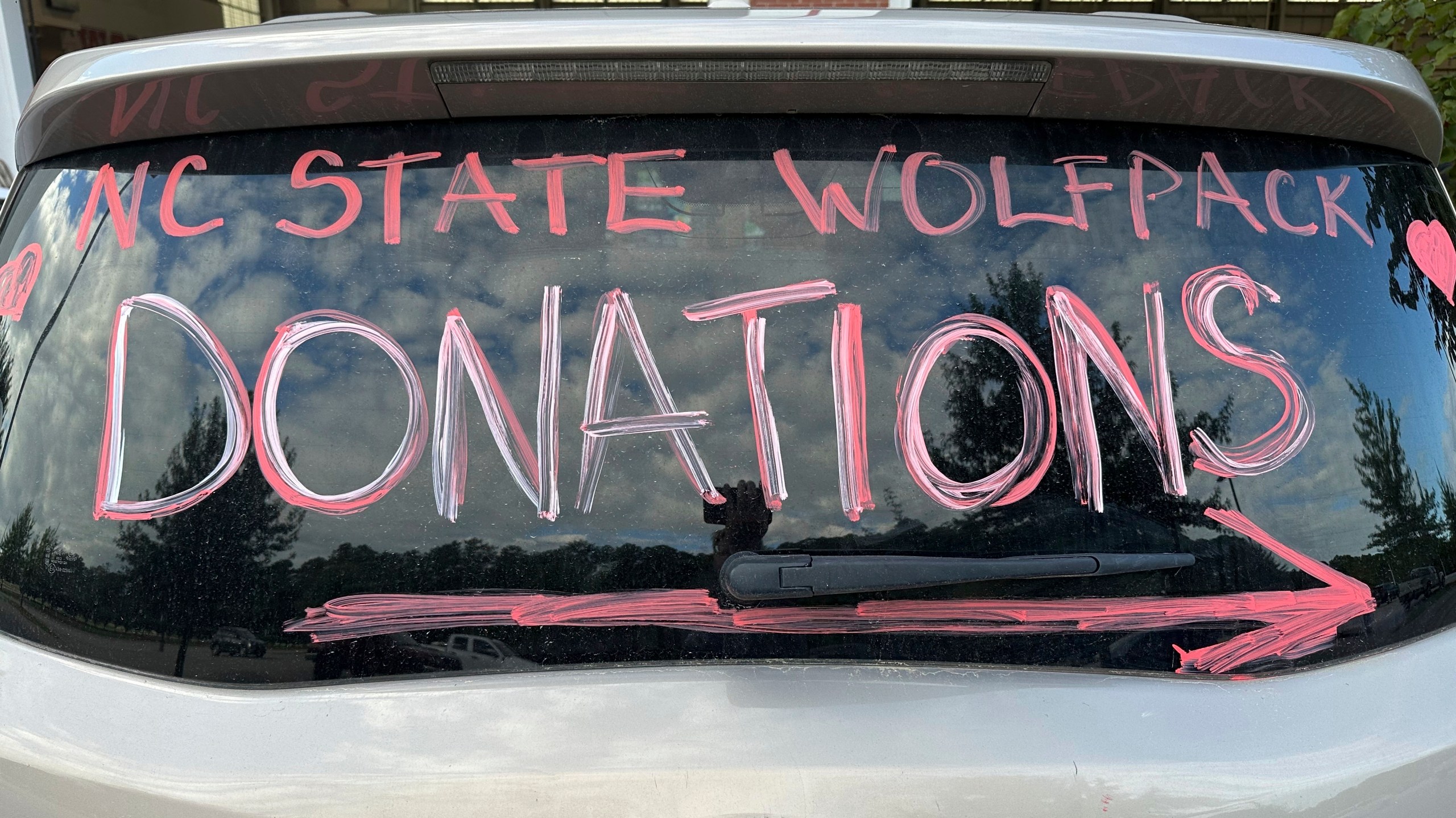 A makeshift sign in a vehicle window helps direct people arriving at a donation drive led by N.C. State defensive end Davin Vann to collect supplies to help Hurricane Helene victims in western North Carolina, Wednesday, Oct. 2, 2024 in Raleigh, N.C. (AP Photo/Aaron Beard)