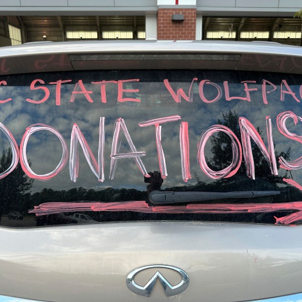 A makeshift sign in a vehicle window helps direct people arriving at a donation drive led by N.C. State defensive end Davin Vann to collect supplies to help Hurricane Helene victims in western North Carolina, Wednesday, Oct. 2, 2024 in Raleigh, N.C. (AP Photo/Aaron Beard)