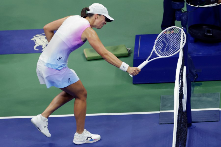 Iga Świątek, of Poland hits the net with her racquet after losing a point to Jessica Pegula, of the United States during the quarterfinals of the U.S. Open tennis championships, Wednesday, Sept. 4, 2024, in New York. (AP Photo/Adam Hunger)