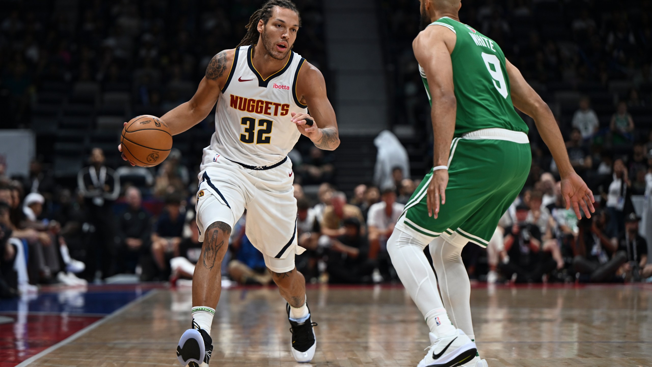 Boston Celtics Derrick White guards Denver Nuggets Aaron Gordon during a preseason game between Boston Celtics and Denver Nuggets in Abu Dhabi, United Arab Emirates, Friday, Oct. 4, 2024. (AP Photo/Martin Dokoupil)