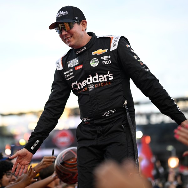 FILE - Kyle Busch interacts with spectators while walking down a runway during driver introductions before a NASCAR Cup Series auto race at Daytona International Speedway, Aug. 24, 2024, in Daytona Beach, Fla. (AP Photo/Phelan M. Ebenhack, File)